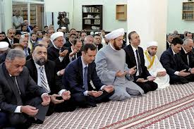 Le président Assad, entouré de responsables, dans une mosquée à Damas

